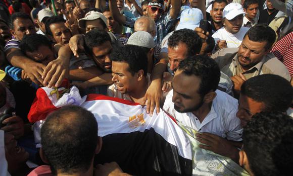 Supporters of Egypt's deposed President Mohamed Mursi carry the body of a fellow supporter killed in violence outside the Republican Guard headquarters in Cairo on Monday. (Reuters)