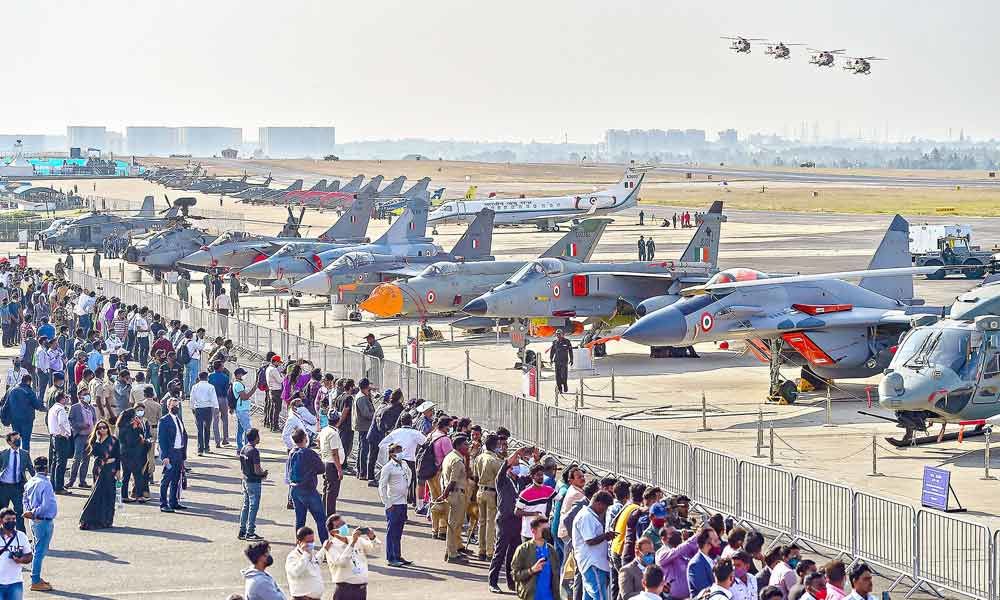 Visitors watch planes on static display during the second day of the 13th edition of Aero India 2021, at Yelahanka air base in Bengaluru on Thursday