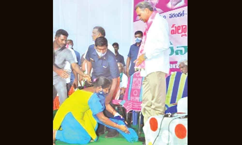 Krishnaveni, an NREGS field assistant falling on the feet of Palla Rajeswara Reddy requesting him to help in retaining her job,